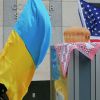 Америка приходит на Украину по-настоящему (Женщина держит флаг Украины посольством США в Киеве | © AP Photo / Efrem Lukatsky) Женщина держит флаг …